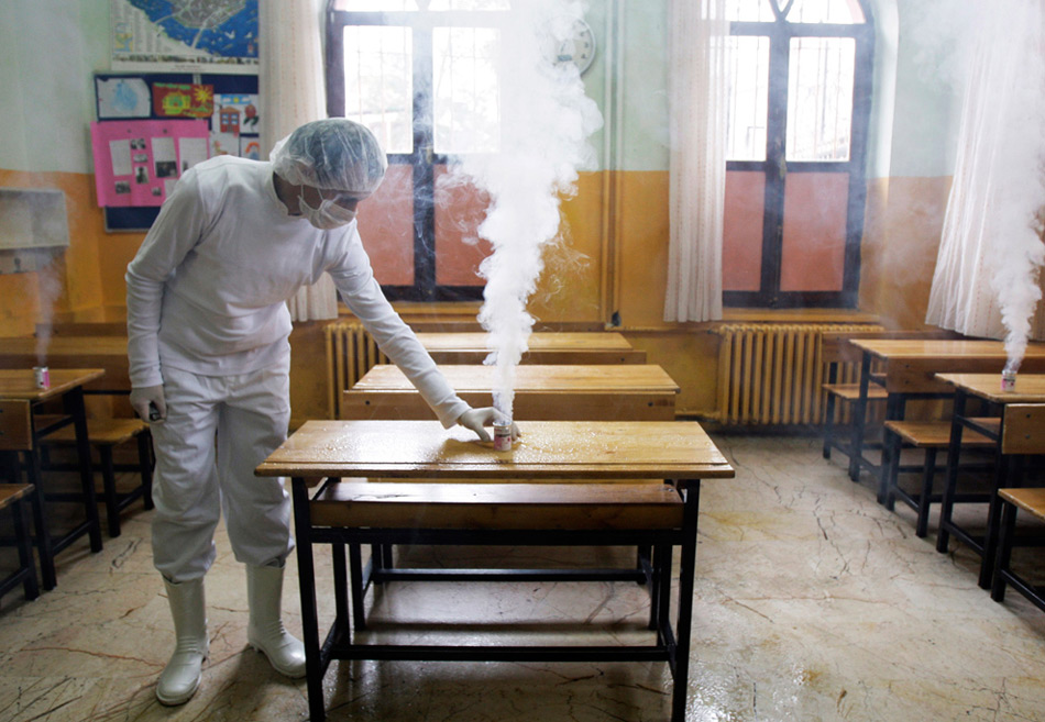 10. Рабочий из муниципальной службы Бейоглу дезинфицирует школьную мебель начальной школы против вируса H1N1 в Стамбуле в пятницу 30 октября 2009 года. Два пациента скончались в Турции от вируса гриппа в четверг, что составило в общей сложности 3 смерти. (AP Photo/Ibrahim Usta)