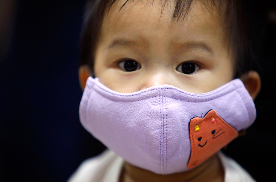 17. Мальчик в маске ожидает своей очереди на вакцинацию в больнице в Тайбэе, Тайвань, 9 ноября 2009 года. В тот день правительство Тайваня начало вакцинацию против вируса H1N1 для детей в возрасте от 6 месяцев до года. (REUTERS/Nicky Loh)