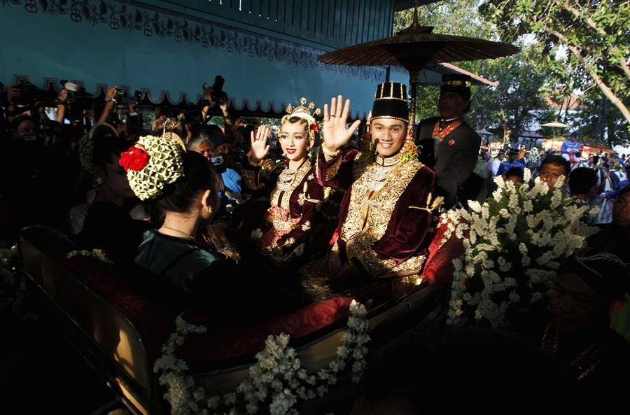 Королевская чета проезжает в конном экипаже по улицам Джакарты