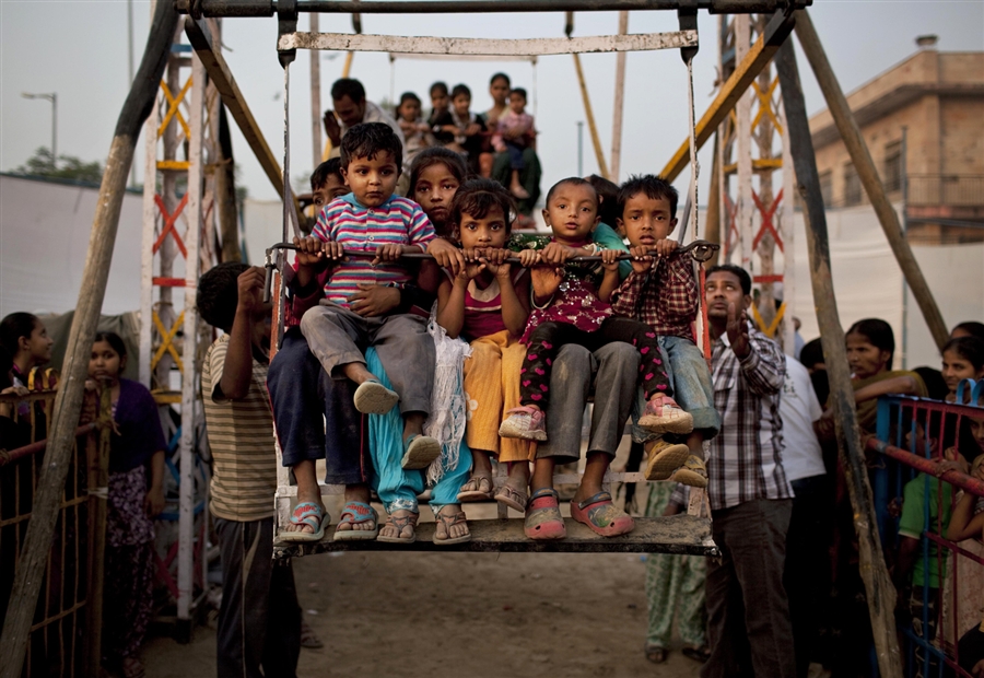 Индийские дети катаются на единственном местном развлечении в Нью-Дели