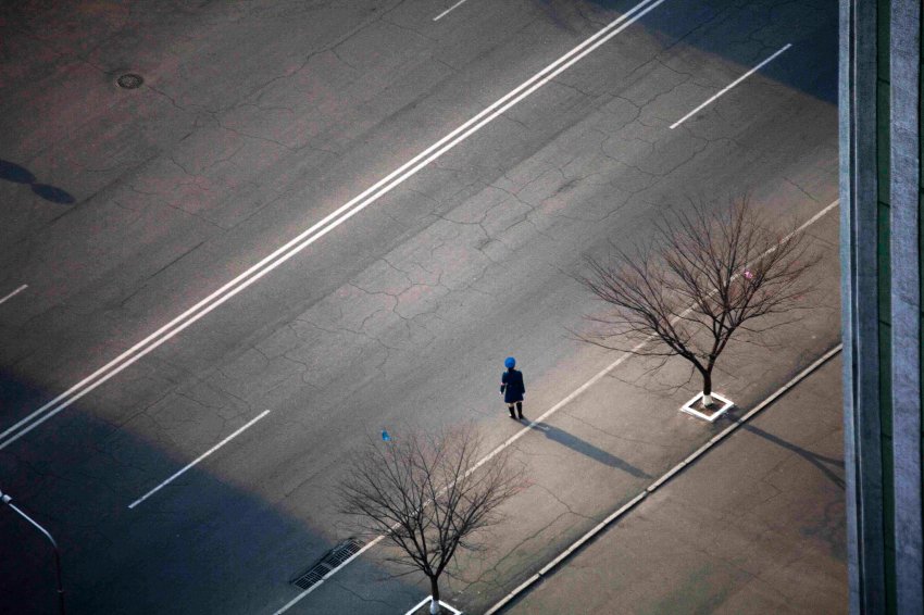 Северокорейский полицейский стоит на пустой улице