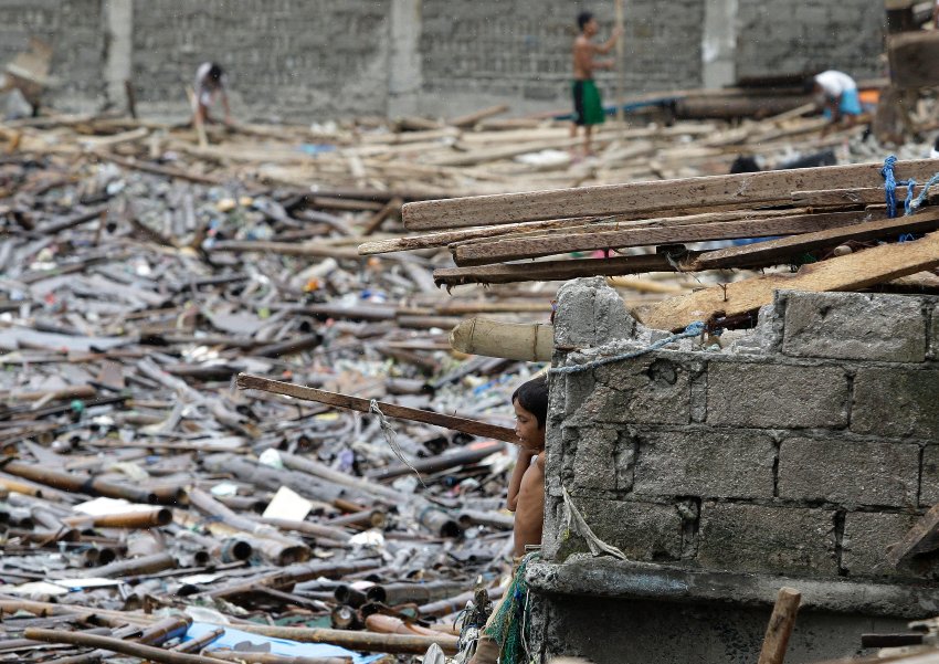Щебень из разрушенных домов в прибрежном городке Navotas, во время последней бури на Филиппинах