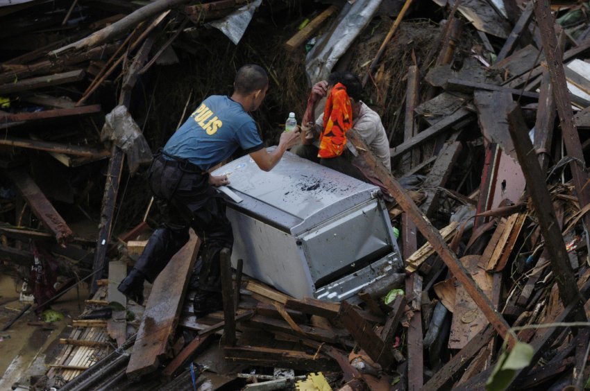 Полицейский оказывает помощь пострадавшим на острове Лусон