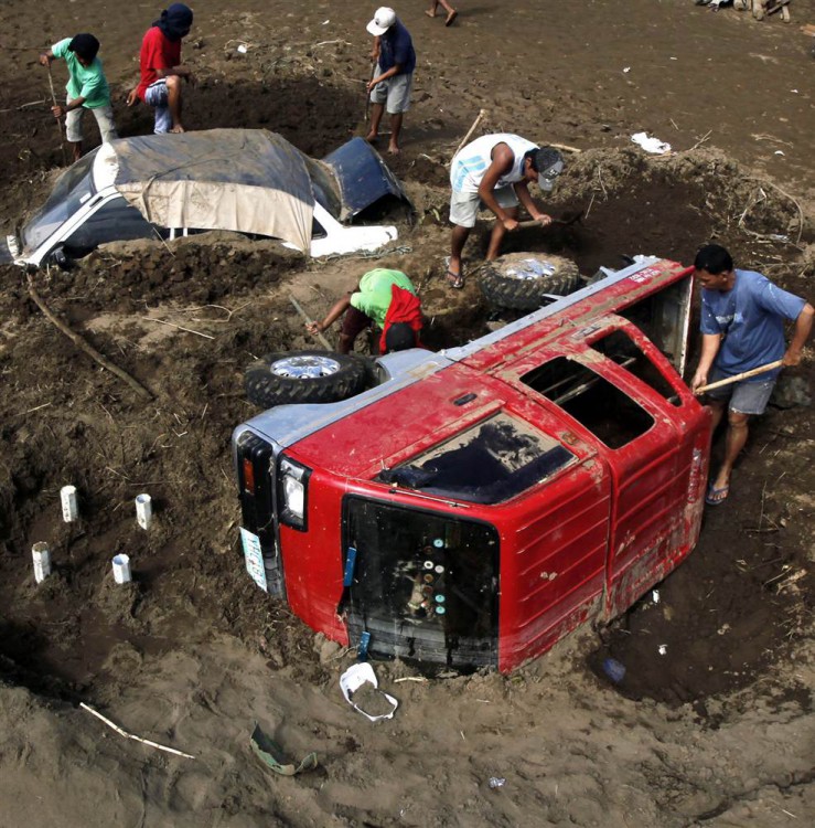 Люди откапывают машины из грязи