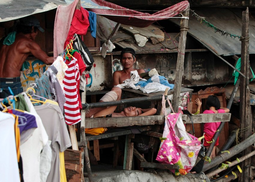 Люди в трущобах Paranaque, к югу от Манилы